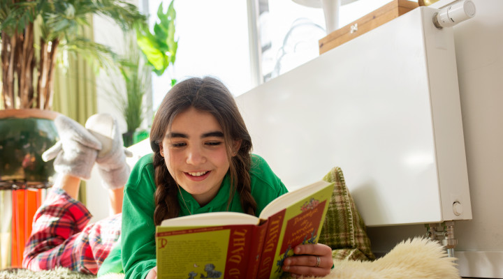 foto van een meisje dat een boek leest in een warm huis