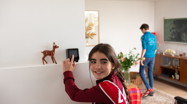 foto van een meisje dat de thermostaat in een woonkamer aanpast